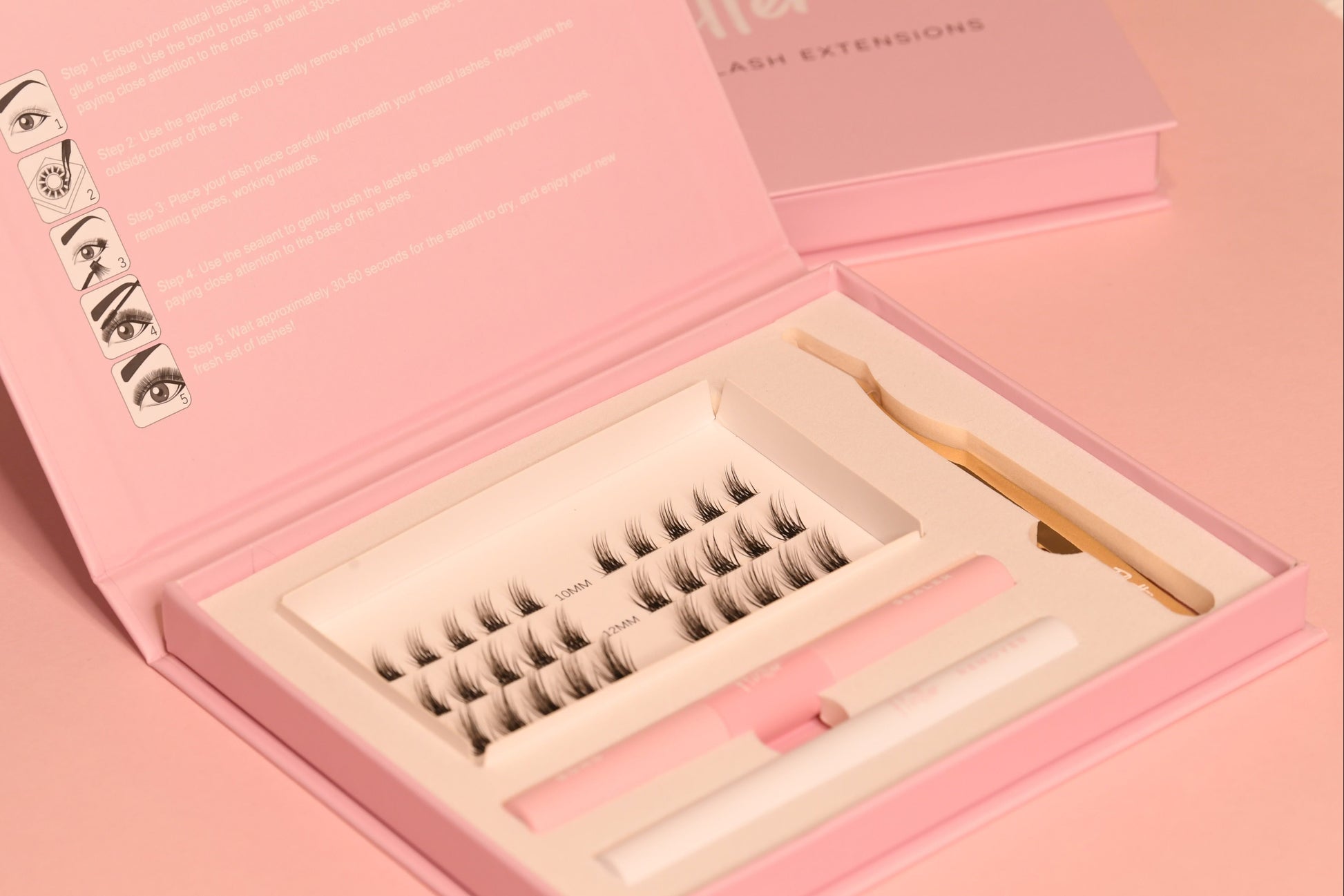Eyelash extensions in a pink box with tools